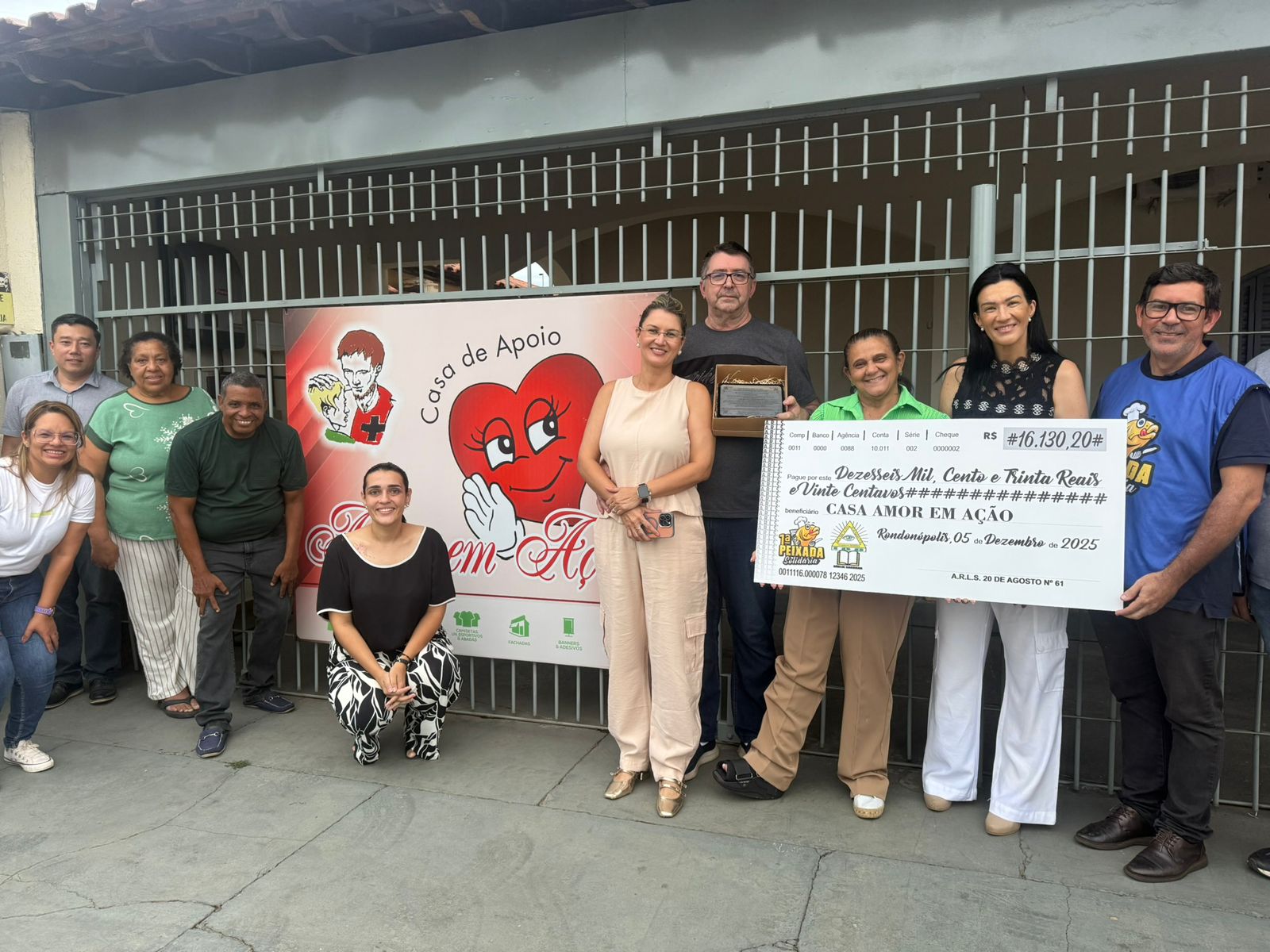 Famílias e cuidadores reunidos em frente a casa de apoio.